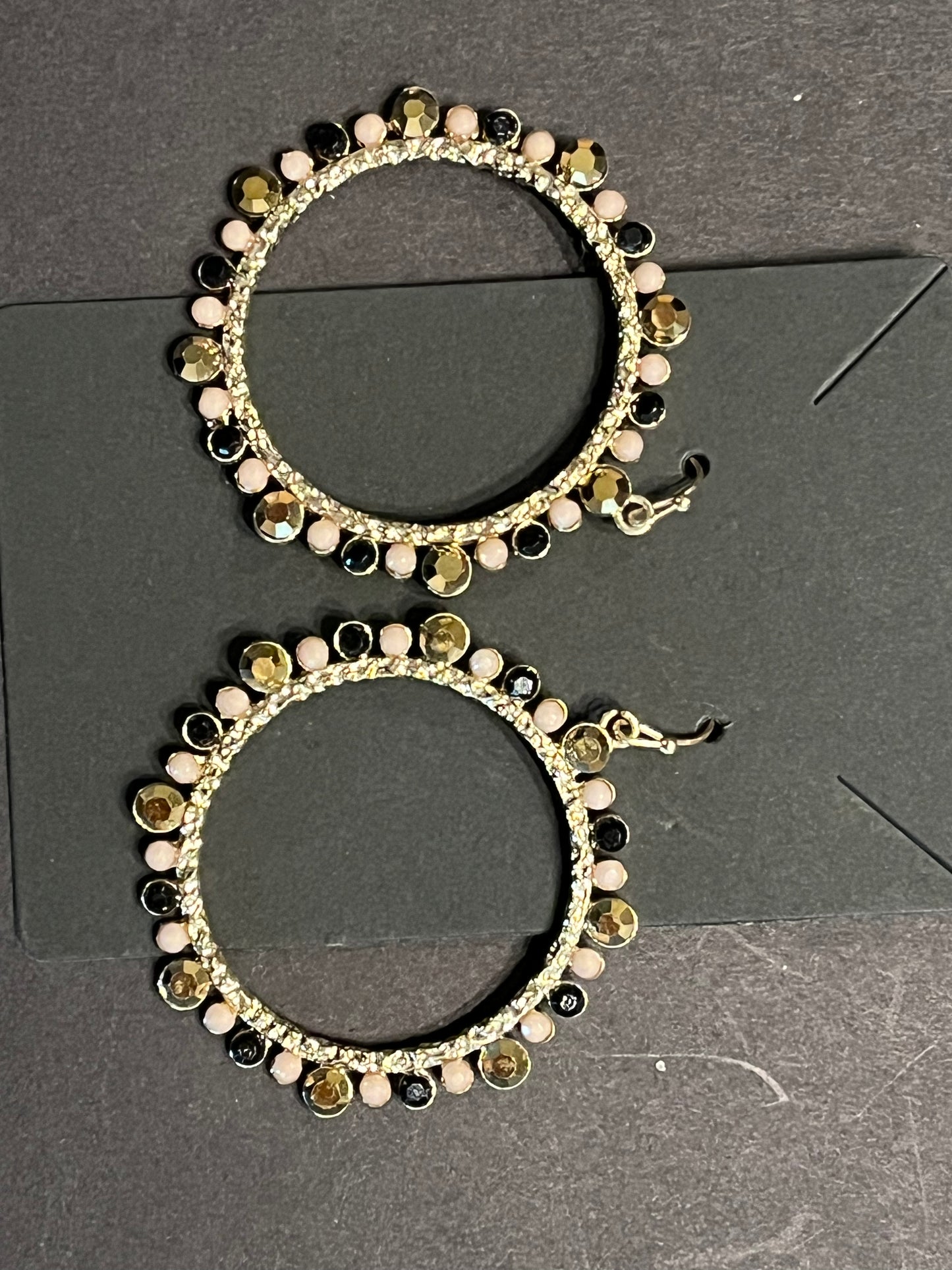 Gold circle earrings with black, gold, and peach gems